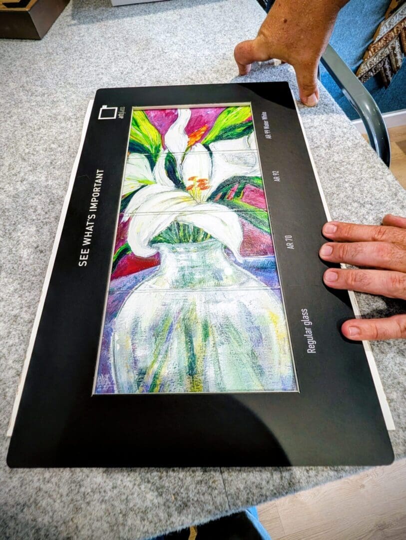 Hands holding colorful flower artwork print.